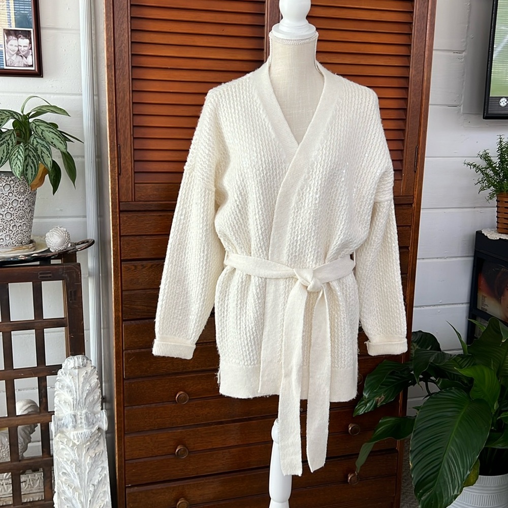 Ladies cream colored belted cardigan sweater with sequins.